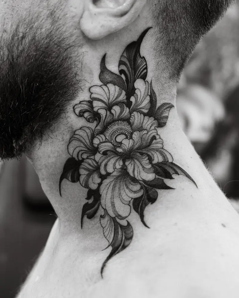 Black and grey peony tattoo curving up the side of a man's neck